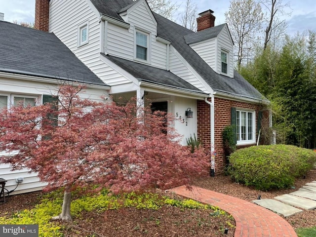 5632 Glenwood Dr, Alexandria, VA 22310 - view of exterior entry featuring a chimney, brick siding, and a shingled roof