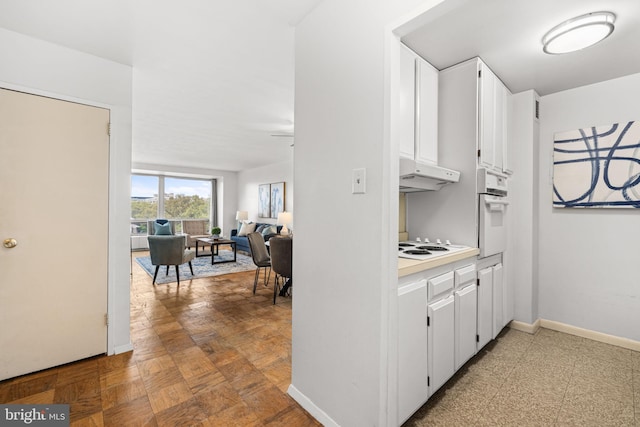 1435 4th St SW Unit B513, Washington, DC 20024 - kitchen with white appliances, under cabinet range hood, white cabinetry, light countertops, and open floor plan