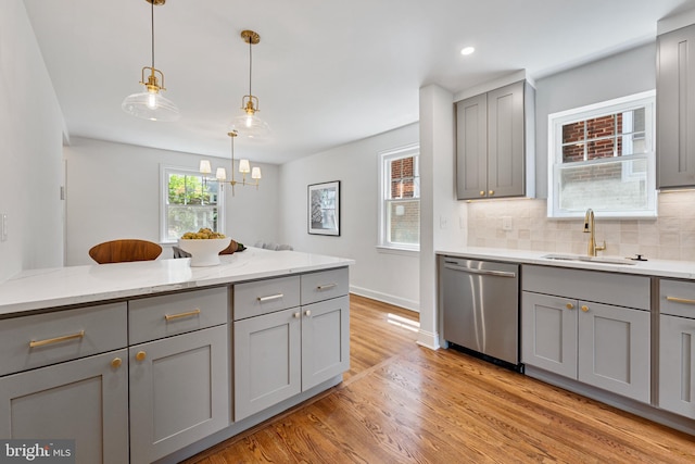 1604 Crittenden St NE, Washington, DC 20017 - kitchen featuring stainless steel dishwasher, gray cabinetry, a sink, light wood-style floors, and light stone counters