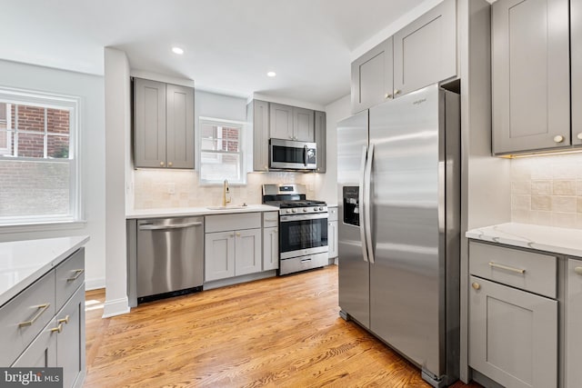 1604 Crittenden St NE, Washington, DC 20017 - kitchen featuring appliances with stainless steel finishes, gray cabinetry, decorative backsplash, a sink, and recessed lighting