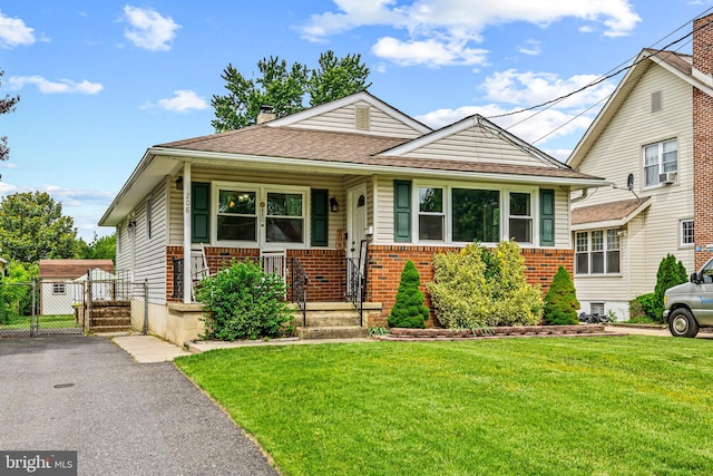 208 N Warwick Rd, Magnolia, NJ 08049 - view of front facade with brick siding, a front yard, a chimney, a shingled roof, and cooling unit