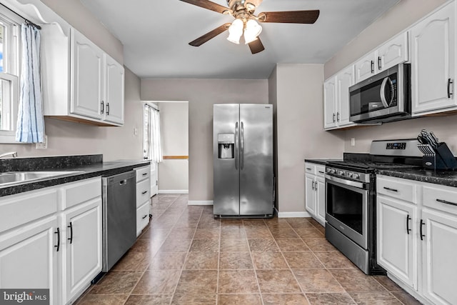 208 N Warwick Rd, Magnolia, NJ 08049 - kitchen with stainless steel appliances, a sink, dark countertops, and a ceiling fan