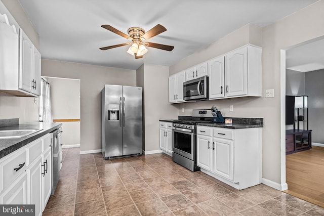 208 N Warwick Rd, Magnolia, NJ 08049 - kitchen with appliances with stainless steel finishes, ceiling fan, dark countertops, and white cabinetry