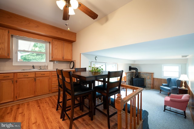 38 Gill Dr, Newark, DE 19713 - dining space with a wood stove, ceiling fan, light wood-style flooring, lofted ceiling, and a wainscoted wall