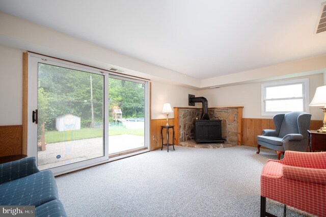 38 Gill Dr, Newark, DE 19713 - living room featuring a wood stove, a wainscoted wall, wooden walls, and carpet