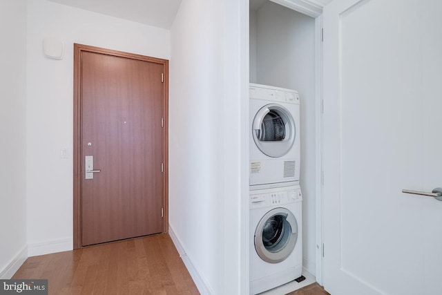 1414 S Penn Sq Unit 28A, Philadelphia, PA 19102 - laundry room featuring estacked washer and dryer, light wood finished floors, and baseboards