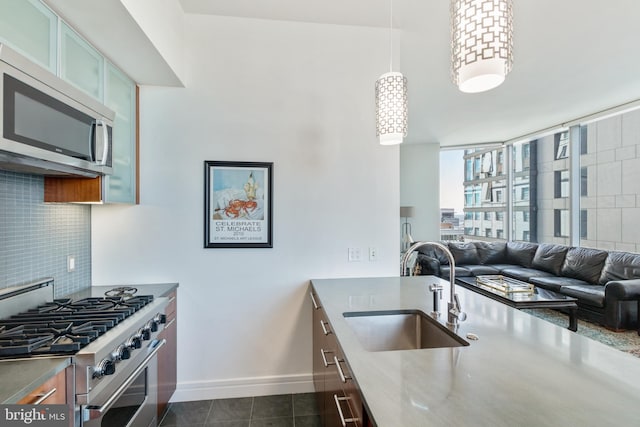 1414 S Penn Sq Unit 28A, Philadelphia, PA 19102 - kitchen featuring stainless steel appliances, a sink, tasteful backsplash, baseboards, and dark tile patterned flooring