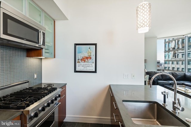 1414 S Penn Sq Unit 28A, Philadelphia, PA 19102 - kitchen with stainless steel appliances, a sink, decorative backsplash, baseboards, and dark countertops