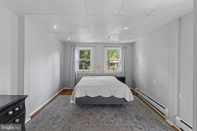 12 E Charles St, Palmyra, NJ 08065 - bedroom with a baseboard radiator, wood finished floors, a paneled ceiling, and recessed lighting