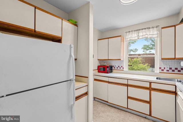 841 Mchenry St, Baltimore, MD 21230 - kitchen with freestanding refrigerator, backsplash, light countertops, and white cabinetry