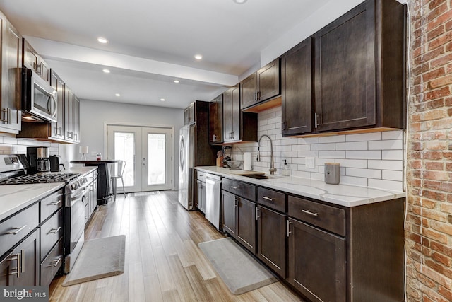 107 W Ostend St, Baltimore, MD 21230 - kitchen featuring appliances with stainless steel finishes, a sink, light wood finished floors, dark brown cabinetry, and recessed lighting