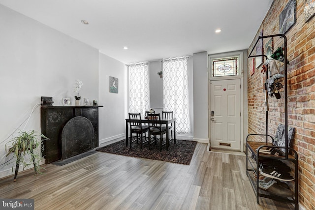 107 W Ostend St, Baltimore, MD 21230 - dining area with wood finished floors, baseboards, a fireplace, recessed lighting, and brick wall