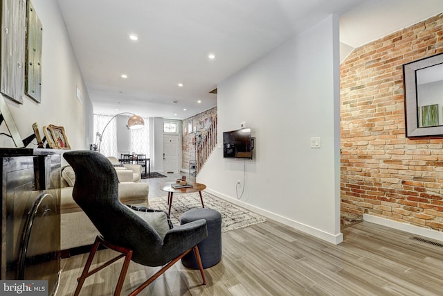 107 W Ostend St, Baltimore, MD 21230 - living area with brick wall, wood finished floors, baseboards, recessed lighting, and stairway