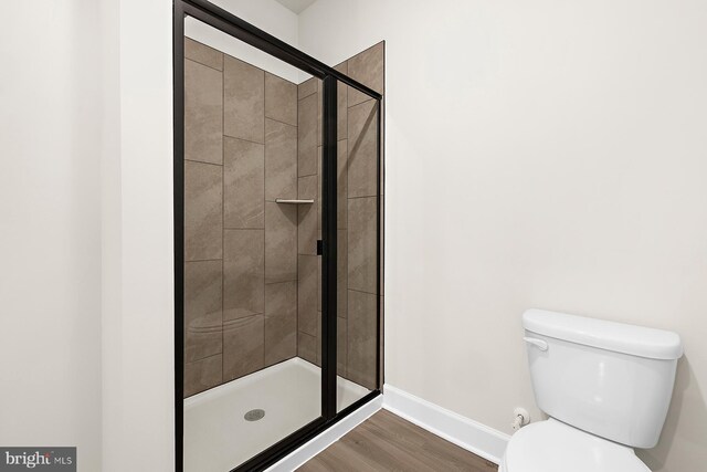 5205 Mccormick Ave, Baltimore, MD 21206 - full bathroom with toilet, a stall shower, baseboards, and wood finished floors