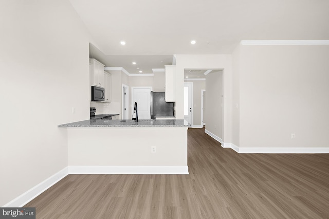 5205 Mccormick Ave, Baltimore, MD 21206 - kitchen with black microwave, range with electric stovetop, fridge, a sink, and wood finished floors