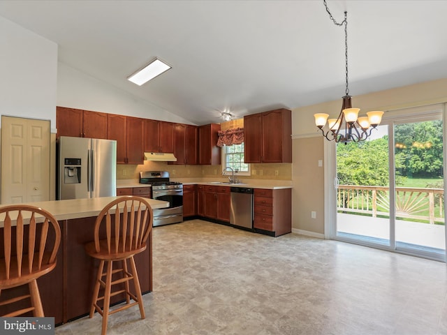 1946 Londontowne Dr, Hagerstown, MD 21740 - kitchen featuring appliances with stainless steel finishes, under cabinet range hood, vaulted ceiling, light countertops, and a chandelier