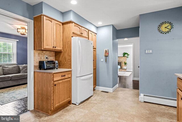 73 Swallow, Southampton, PA 18966 - kitchen featuring freestanding refrigerator, a baseboard heating unit, light countertops, backsplash, and baseboards