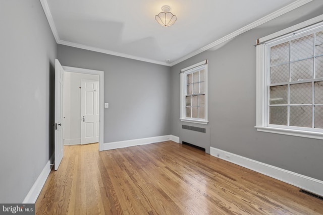 4036 Roland Ave, Baltimore, MD 21211 - spare room featuring radiator, ornamental molding, light wood-style flooring, baseboards, and plenty of natural light