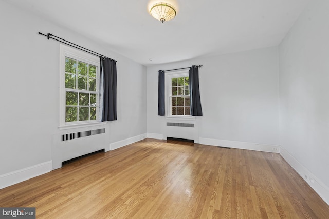 4036 Roland Ave, Baltimore, MD 21211 - empty room featuring radiator heating unit, plenty of natural light, and wood finished floors