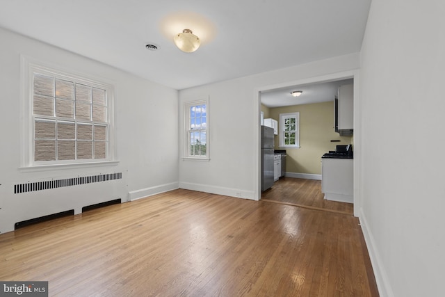 4036 Roland Ave, Baltimore, MD 21211 - spare room featuring radiator heating unit, hardwood / wood-style flooring, and baseboards