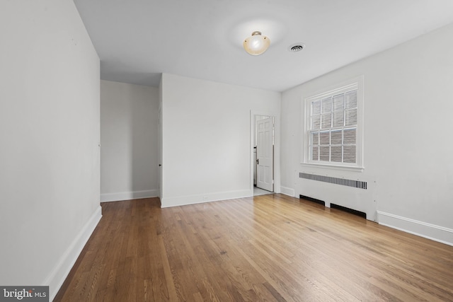 4036 Roland Ave, Baltimore, MD 21211 - empty room featuring radiator, wood finished floors, and baseboards