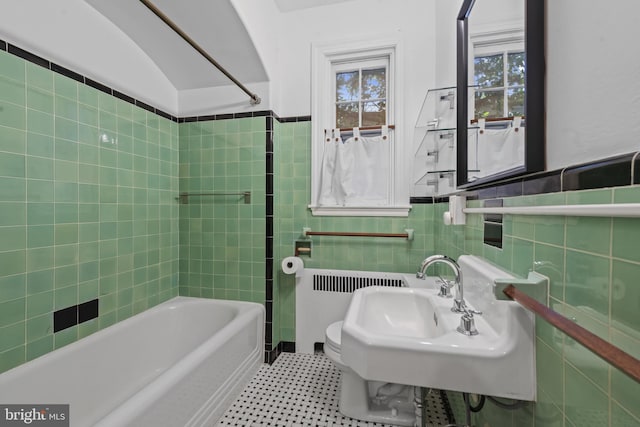 4036 Roland Ave, Baltimore, MD 21211 - bathroom featuring tile walls, radiator heating unit, bathtub / shower combination, toilet, and a sink