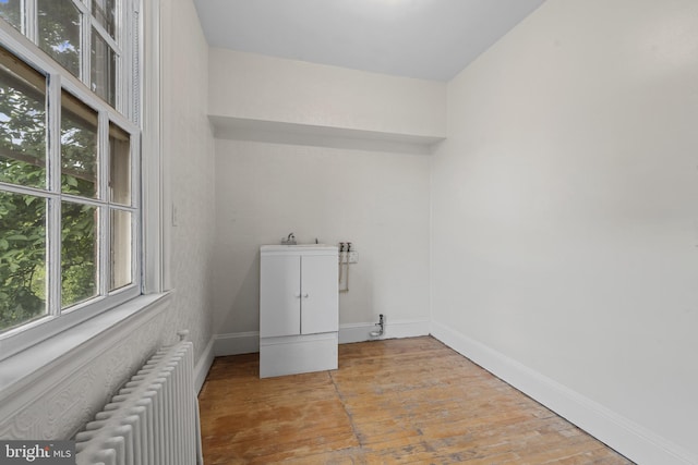 4036 Roland Ave, Baltimore, MD 21211 - laundry area featuring radiator, hardwood / wood-style floors, and baseboards