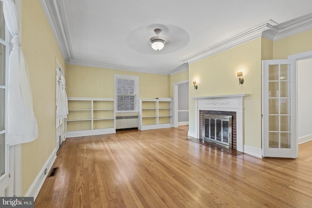 4036 Roland Ave, Baltimore, MD 21211 - unfurnished living room featuring radiator heating unit, ornamental molding, a fireplace, ceiling fan, and wood finished floors