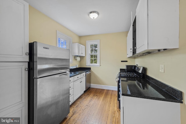 4036 Roland Ave, Baltimore, MD 21211 - kitchen with stainless steel appliances, white cabinets, baseboards, and light wood finished floors