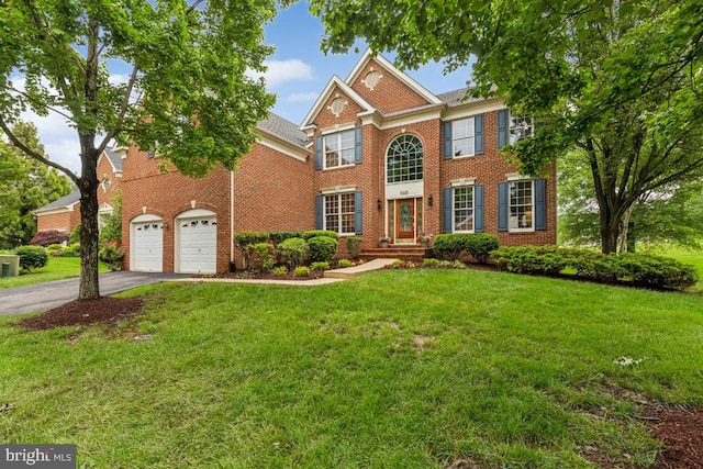 43229 Augustine Pl, Ashburn, VA 20147 - colonial home featuring driveway, brick siding, a front lawn, and a garage