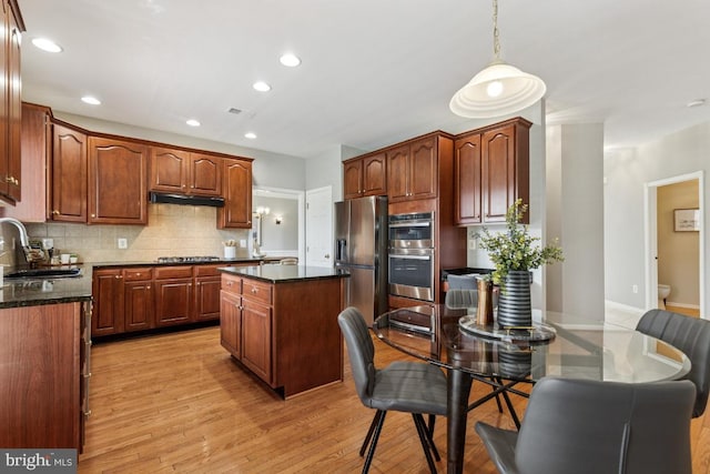 43229 Augustine Pl, Ashburn, VA 20147 - kitchen featuring appliances with stainless steel finishes, a sink, decorative backsplash, light wood-style floors, and a center island