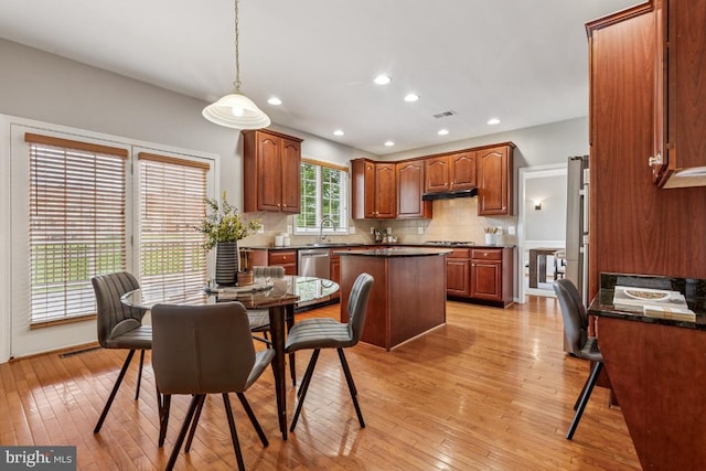 43229 Augustine Pl, Ashburn, VA 20147 - kitchen with dark countertops, a sink, under cabinet range hood, a center island, and recessed lighting