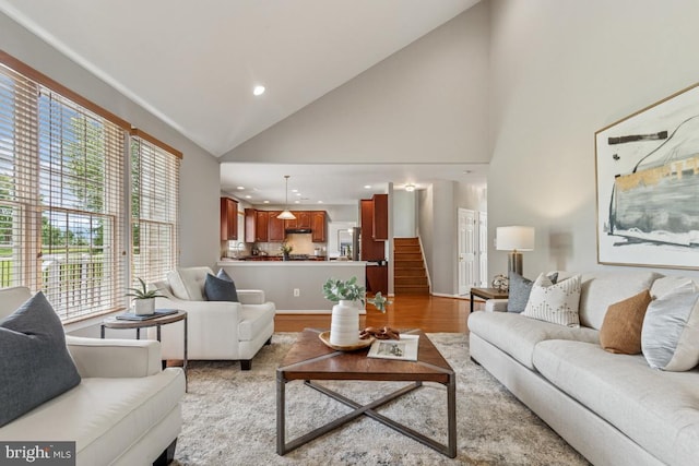 43229 Augustine Pl, Ashburn, VA 20147 - living room with healthy amount of natural light, wood finished floors, high vaulted ceiling, recessed lighting, and stairs