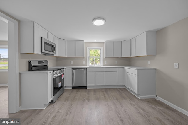 10561 Georgetown Rd, Laurel, DE 19956 - kitchen featuring appliances with stainless steel finishes, baseboards, light wood-style floors, and light countertops