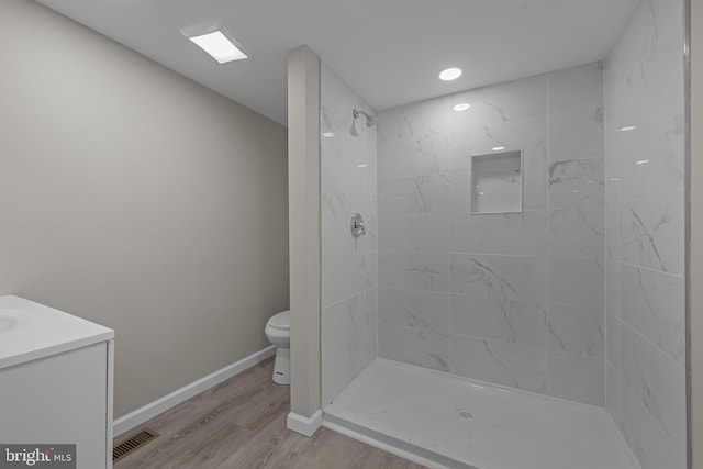 10561 Georgetown Rd, Laurel, DE 19956 - bathroom featuring toilet, tiled shower, vanity, wood finished floors, and baseboards