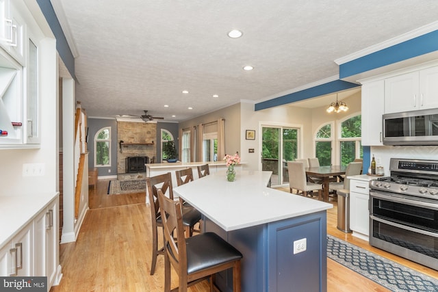 8 Lochwell Ct, Baltimore, MD 21234 - kitchen featuring stainless steel appliances, a textured ceiling, white cabinets, open floor plan, and a fireplace