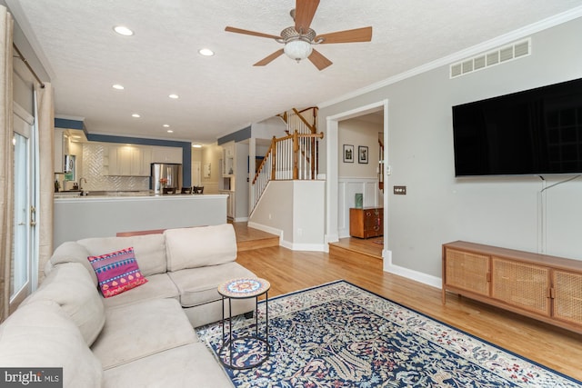 8 Lochwell Ct, Baltimore, MD 21234 - living room featuring light wood-style floors, a ceiling fan, recessed lighting, crown molding, and stairway