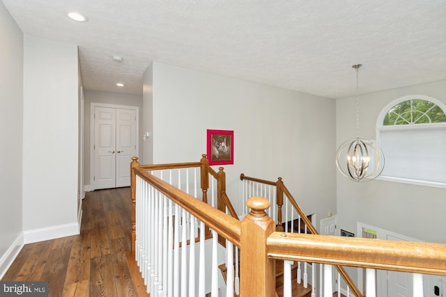 8 Lochwell Ct, Baltimore, MD 21234 - hallway featuring an upstairs landing, a chandelier, wood-type flooring, a textured ceiling, and baseboards