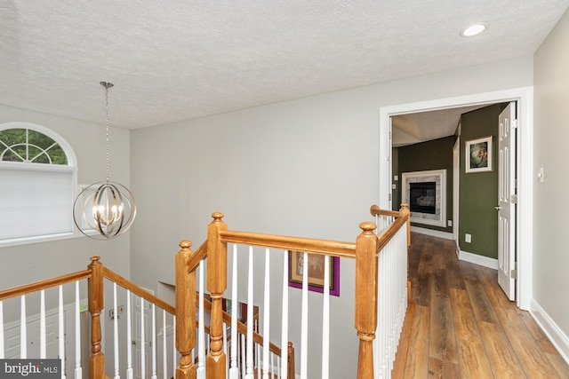 8 Lochwell Ct, Baltimore, MD 21234 - hallway with an upstairs landing, a chandelier, hardwood / wood-style floors, a textured ceiling, and baseboards