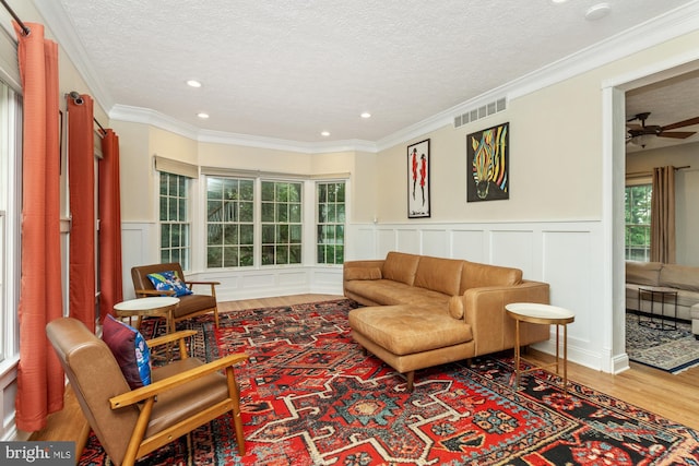 8 Lochwell Ct, Baltimore, MD 21234 - living room featuring a decorative wall, a textured ceiling, wood finished floors, a wainscoted wall, and healthy amount of natural light