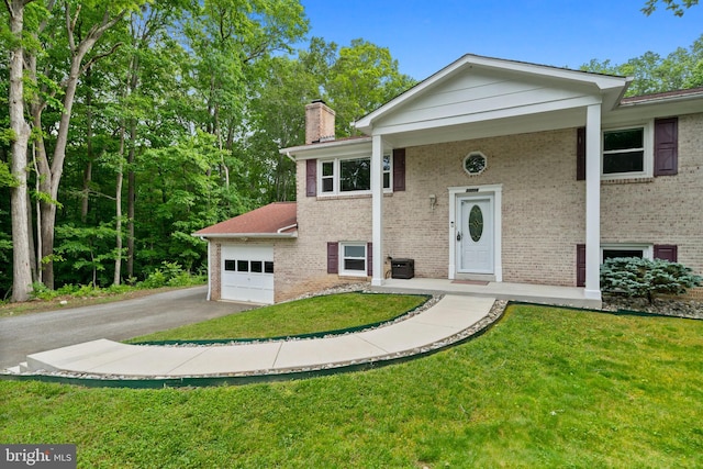 13712 S Springfield Rd, Brandywine, MD 20613 - bi-level home featuring asphalt driveway, an attached garage, brick siding, and a chimney
