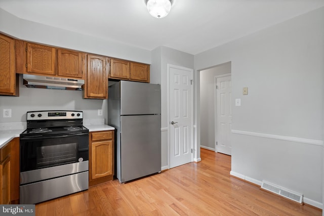 13712 S Springfield Rd, Brandywine, MD 20613 - kitchen with appliances with stainless steel finishes, under cabinet range hood, brown cabinetry, and light countertops