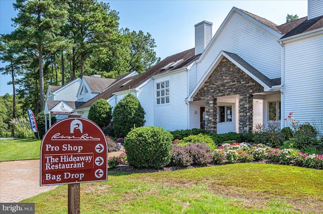12545 River Run Ln Unit 68, Berlin, MD 21811 - exterior space featuring a chimney, stone siding, and a yard