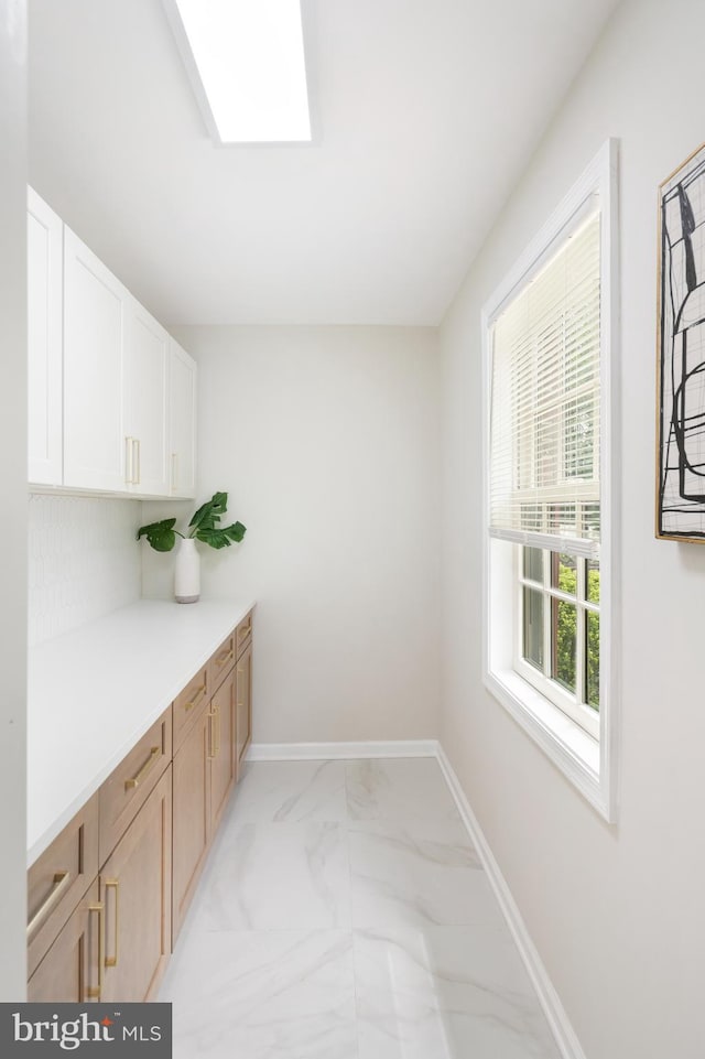 517 Worcester, Towson, MD 21286 - laundry room featuring light marble finish floors, baseboards, and a skylight