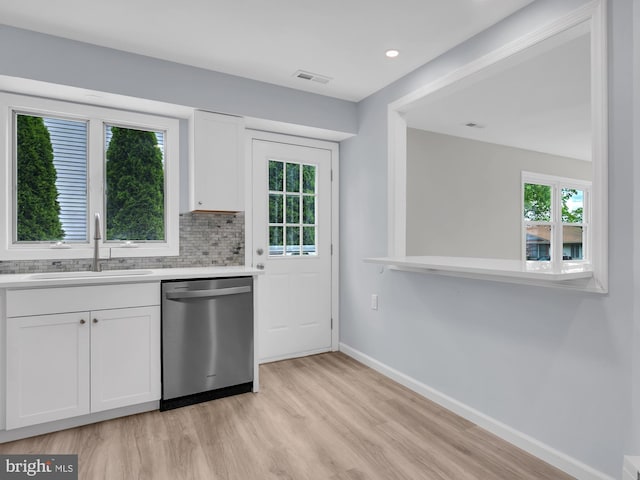 28 Sycamore Rd Unit 45, Manahawkin, NJ 08050 - kitchen with stainless steel dishwasher, a sink, baseboards, light wood finished floors, and white cabinetry