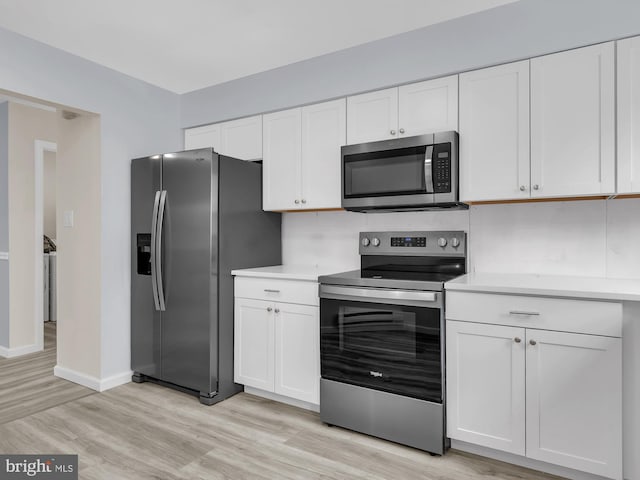 28 Sycamore Rd Unit 45, Manahawkin, NJ 08050 - kitchen featuring appliances with stainless steel finishes, light countertops, white cabinets, and light wood finished floors