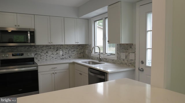 28 Sycamore Rd Unit 45, Manahawkin, NJ 08050 - kitchen featuring stainless steel appliances, a sink, decorative backsplash, light countertops, and white cabinetry