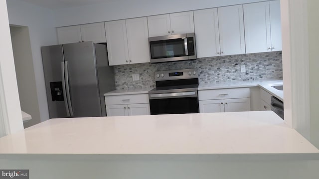 28 Sycamore Rd Unit 45, Manahawkin, NJ 08050 - kitchen with stainless steel appliances, decorative backsplash, light countertops, and white cabinetry