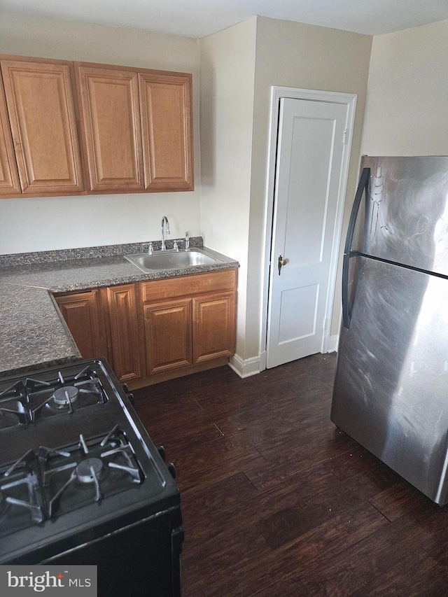 423 Gusryan St, Baltimore, MD 21224 - kitchen featuring a sink, freestanding refrigerator, black gas range oven, dark wood-style floors, and dark countertops