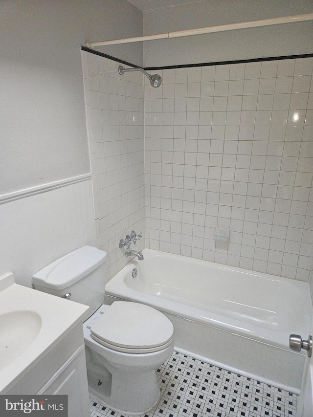 423 Gusryan St, Baltimore, MD 21224 - bathroom featuring vanity, toilet, shower / bathtub combination, tile patterned floors, and wainscoting